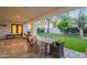 Inviting covered patio area featuring a dining table, lounge chairs, and manicured yard at 10532 N 79Th St, Scottsdale, AZ 85258