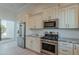 Modern kitchen with stainless steel appliances, granite countertops, and white cabinets at 10532 N 79Th St, Scottsdale, AZ 85258