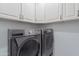 Laundry room area featuring side-by-side washer and dryer with upper cabinet storage at 10532 N 79Th St, Scottsdale, AZ 85258