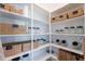 Organized walk-in pantry with white shelving and an assortment of wicker baskets and glass jars at 10532 N 79Th St, Scottsdale, AZ 85258