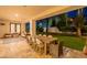 Outdoor living on a covered patio with dining and seating areas, offering a tranquil view of the backyard at 10532 N 79Th St, Scottsdale, AZ 85258