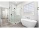 Bright bathroom featuring a modern soaking tub, glass shower, and large window at 1096 E Lodgepole Dr, Gilbert, AZ 85298