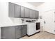 Well-organized laundry room features gray cabinets and modern washer and dryer units at 1096 E Lodgepole Dr, Gilbert, AZ 85298