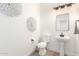Stylish powder room with a pedestal sink, modern fixtures, and decorative wall art, adding elegance to the space at 1096 E Lodgepole Dr, Gilbert, AZ 85298