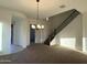 Inviting living room with high ceilings, staircase with wrought iron railing, and stylish light fixture at 10984 N 164Th Dr, Surprise, AZ 85388