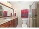 Bathroom featuring granite countertops, wooden vanity, and tiled glass door shower at 1146 E Rovey Ave, Phoenix, AZ 85014