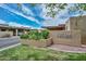 Riviera Gardens community entrance with lush landscaping and covered parking, under a bright blue sky at 1146 E Rovey Ave, Phoenix, AZ 85014