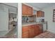 The kitchen provides a view to the dining room and living room and features tile flooring and wooden cabinets at 1146 E Rovey Ave, Phoenix, AZ 85014