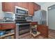 This kitchen includes stainless steel appliances, a gas range, pull out cabinet and wooden cabinets at 1146 E Rovey Ave, Phoenix, AZ 85014