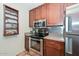 This kitchen features stainless steel appliances, a spice rack and wooden cabinets at 1146 E Rovey Ave, Phoenix, AZ 85014