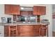 The kitchen includes wooden cabinets, granite countertops, tile backsplash, stainless steel appliances and a breakfast bar at 1146 E Rovey Ave, Phoenix, AZ 85014