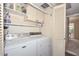 Functional laundry room with washer, dryer, shelving, and storage cabinets at 1146 E Rovey Ave, Phoenix, AZ 85014