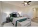 Well-lit bedroom with an upholstered bench, ceiling fan, and a large bed with green bedding at 123 N Washington St # 16, Chandler, AZ 85225