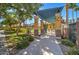 Wrought-iron gate leading to a community area, with lush landscaping and trees, offering a welcoming and secure entrance at 123 N Washington St # 16, Chandler, AZ 85225
