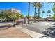 Charming street view featuring well-maintained landscaping, tall palm trees and a gated entrance to the community at 123 N Washington St # 16, Chandler, AZ 85225