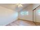 Bright bedroom with vaulted ceiling, ceiling fan, wood-look floors, and mirrored closet at 12445 N 21St Ave # 4, Phoenix, AZ 85029