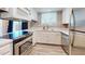 Updated kitchen features quartz countertops, white cabinets, tile backsplash, stainless appliances, and modern wood-look flooring at 12445 N 21St Ave # 4, Phoenix, AZ 85029