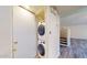 Convenient laundry area featuring a stacked washer and dryer, next to a staircase and wood-look flooring at 12445 N 21St Ave # 4, Phoenix, AZ 85029