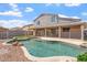 Spacious backyard featuring a sparkling pool, desert landscaping, and a covered patio at 12745 W Calavar Rd, El Mirage, AZ 85335