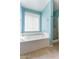 Well-lit bathroom with a bathtub, separate shower, and a window offering natural light at 12745 W Calavar Rd, El Mirage, AZ 85335