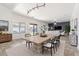 Open-concept dining area with a modern table, tile flooring, and seamless transition to the living room at 12745 W Calavar Rd, El Mirage, AZ 85335
