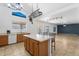 Bright kitchen opens to living space and features an island, tile floor, pendant lighting, and backyard views at 12745 W Calavar Rd, El Mirage, AZ 85335