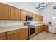 Bright kitchen features wood cabinets, stainless steel appliances, tiled flooring, and plenty of counter space at 12745 W Calavar Rd, El Mirage, AZ 85335