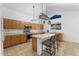 Bright kitchen with wooden cabinets, matching appliances, a center island and a cozy breakfast bar at 12745 W Calavar Rd, El Mirage, AZ 85335