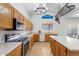 Traditional kitchen features wood cabinets, island, vaulted ceiling, tile flooring, and modern appliances at 12745 W Calavar Rd, El Mirage, AZ 85335
