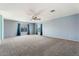 Large living room with carpet flooring, ceiling fan, and neutral-colored walls at 12745 W Calavar Rd, El Mirage, AZ 85335
