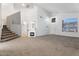 Spacious living room with vaulted ceilings, a cozy fireplace, plush carpet and stairway access at 12745 W Calavar Rd, El Mirage, AZ 85335