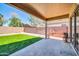 Covered patio area extends to an artificial turf yard, enclosed by a brick wall, perfect for outdoor enjoyment at 12938 W Mandalay Ln, El Mirage, AZ 85335