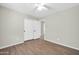A bright bedroom with wood-look floors, ceiling fan, and a closet with folding doors at 12938 W Mandalay Ln, El Mirage, AZ 85335