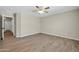 A spacious bedroom features wood-look flooring, a ceiling fan, and an adjoining door at 12938 W Mandalay Ln, El Mirage, AZ 85335