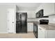 Functional kitchen with white cabinets, neutral countertops, and black appliances at 12938 W Mandalay Ln, El Mirage, AZ 85335
