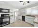 Bright kitchen with white cabinetry, tile floors, and black appliances for a modern touch at 12938 W Mandalay Ln, El Mirage, AZ 85335