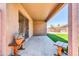 A covered patio with a concrete floor, wooden furniture and a view of the grassy backyard beyond at 12938 W Mandalay Ln, El Mirage, AZ 85335
