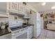 Kitchen with white appliances, light wood-look floors, and white cabinetry at 13211 W Aleppo Dr, Sun City West, AZ 85375