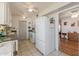 A kitchen featuring white appliances, tile flooring, and a view into an adjacent room at 13211 W Aleppo Dr, Sun City West, AZ 85375