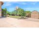 Spacious backyard with a basketball hoop, storage shed, and mature trees, perfect for outdoor activities at 1338 W Mountain View Dr, Mesa, AZ 85201