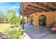 Charming covered patio with tile flooring, ornate archways, lounge chairs, and verdant landscape views at 1338 W Mountain View Dr, Mesa, AZ 85201