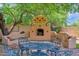 Charming backyard with a custom outdoor fireplace, seating, and lush landscaping offering a private retreat at 1338 W Mountain View Dr, Mesa, AZ 85201