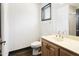 Bright bathroom with a wooden vanity, neutral countertop, brushed nickel faucet, and a framed window for natural light at 14123 W Greentree S Dr, Litchfield Park, AZ 85340