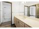 Bathroom with wood vanity, tiled floor, and shower with glass door at 14123 W Greentree S Dr, Litchfield Park, AZ 85340