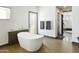 Bright bathroom features a modern soaking tub, tiled floors and doorway access at 14123 W Greentree S Dr, Litchfield Park, AZ 85340