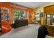 This is a cozy bedroom featuring natural light and a unique orange accent wall at 14123 W Greentree S Dr, Litchfield Park, AZ 85340