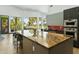 Kitchen with large center island and stainless steel appliances, next to the living area at 14123 W Greentree S Dr, Litchfield Park, AZ 85340