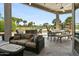 This covered patio offers a comfortable seating area and dining space with golf course views at 14123 W Greentree S Dr, Litchfield Park, AZ 85340