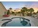 This backyard boasts a beautiful sparkling pool, spa, patio, desert landscaping, and palm trees at 14123 W Greentree S Dr, Litchfield Park, AZ 85340