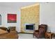 Bright sitting room with a striking fireplace, painting, and comfortable chairs at 14123 W Greentree S Dr, Litchfield Park, AZ 85340